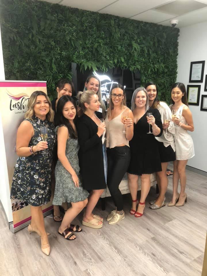 lash tribe students cheering in front of a green wall after a training