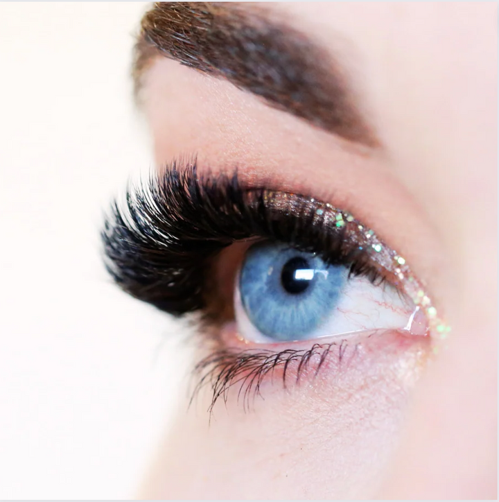 A close up of a woman's eye with long 0.05 Russian Volume Lashes from the Lash Tribe luxurious premium silk collection.
