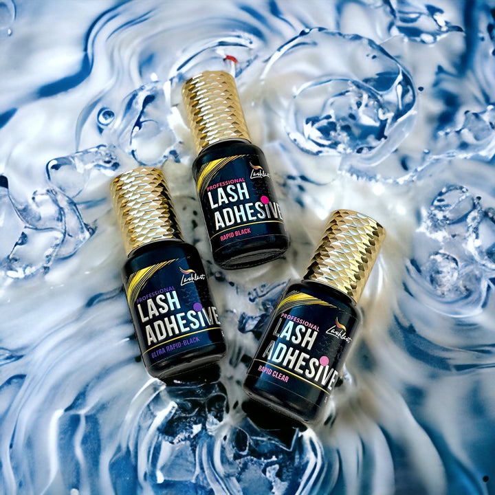 three bottles of Eyelash Adhesive Bundle from Lash Tribe™️ sitting on top of water.