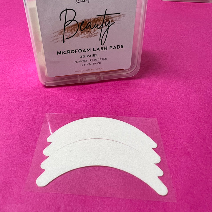 A package of Lash Tribe Microfoam Eye Pads on a pink background.