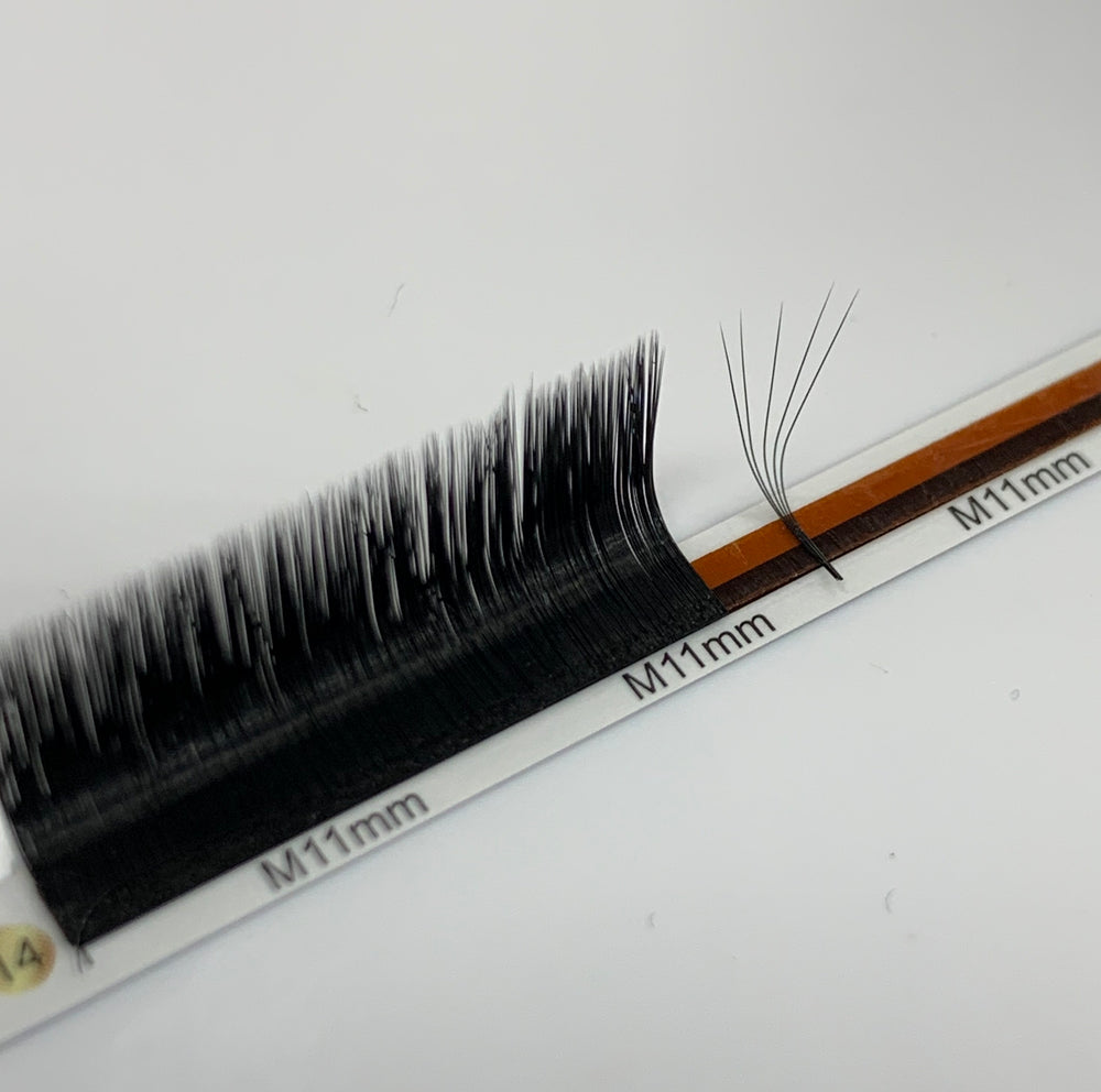 A pair of Lash Tribe's EASY FAN LASHES | SELF FLOWERING EYELASH EXTENSIONS | JET BLACK on a white surface.