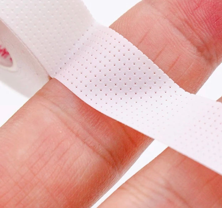 A person's hand holding a piece of Lash Tribe's Japanese Comfort Lash Tape | Breathable Tape | Eyelash Extensions Tape