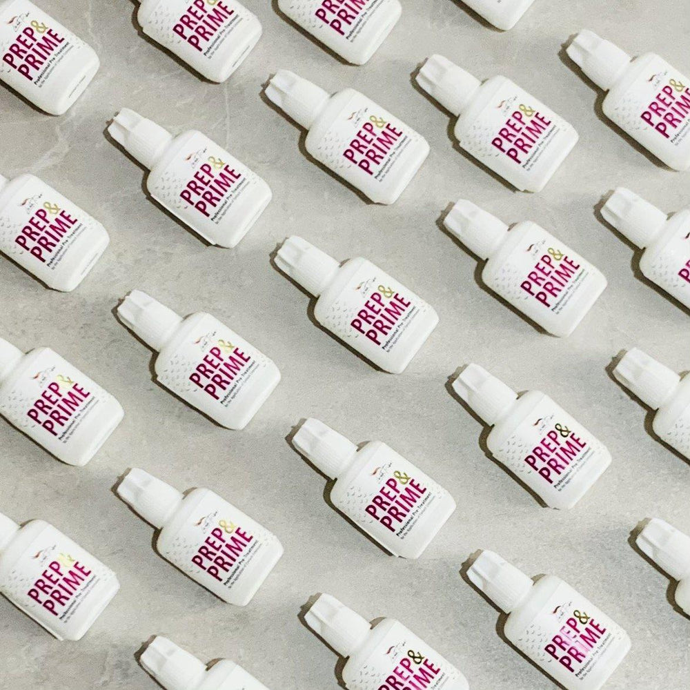 a group of Lash Tribe white bottles with a pink label on them.