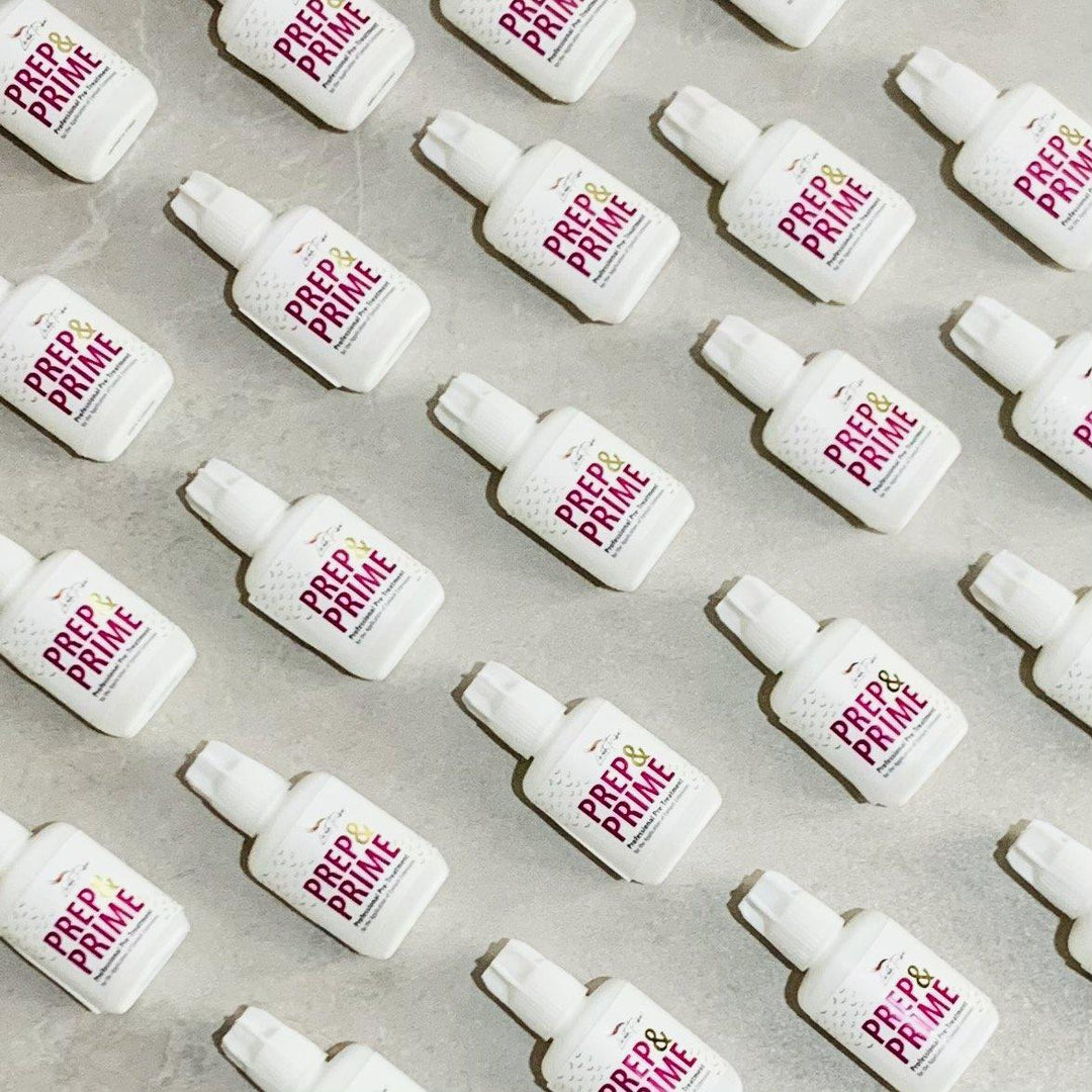 a group of Lash Tribe white bottles with a pink label on them.