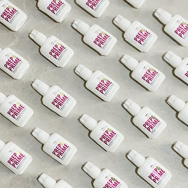 a group of Lash Tribe white bottles with a pink label on them.