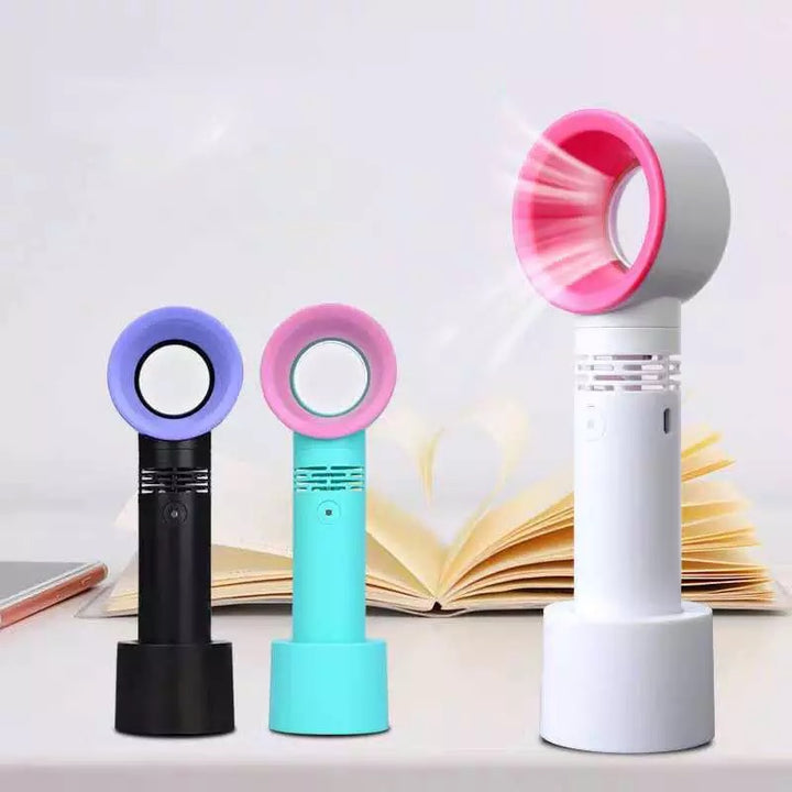 A small Lash Drying Fan for Eyelash Extensions by Lash Tribe sitting on top of a book.