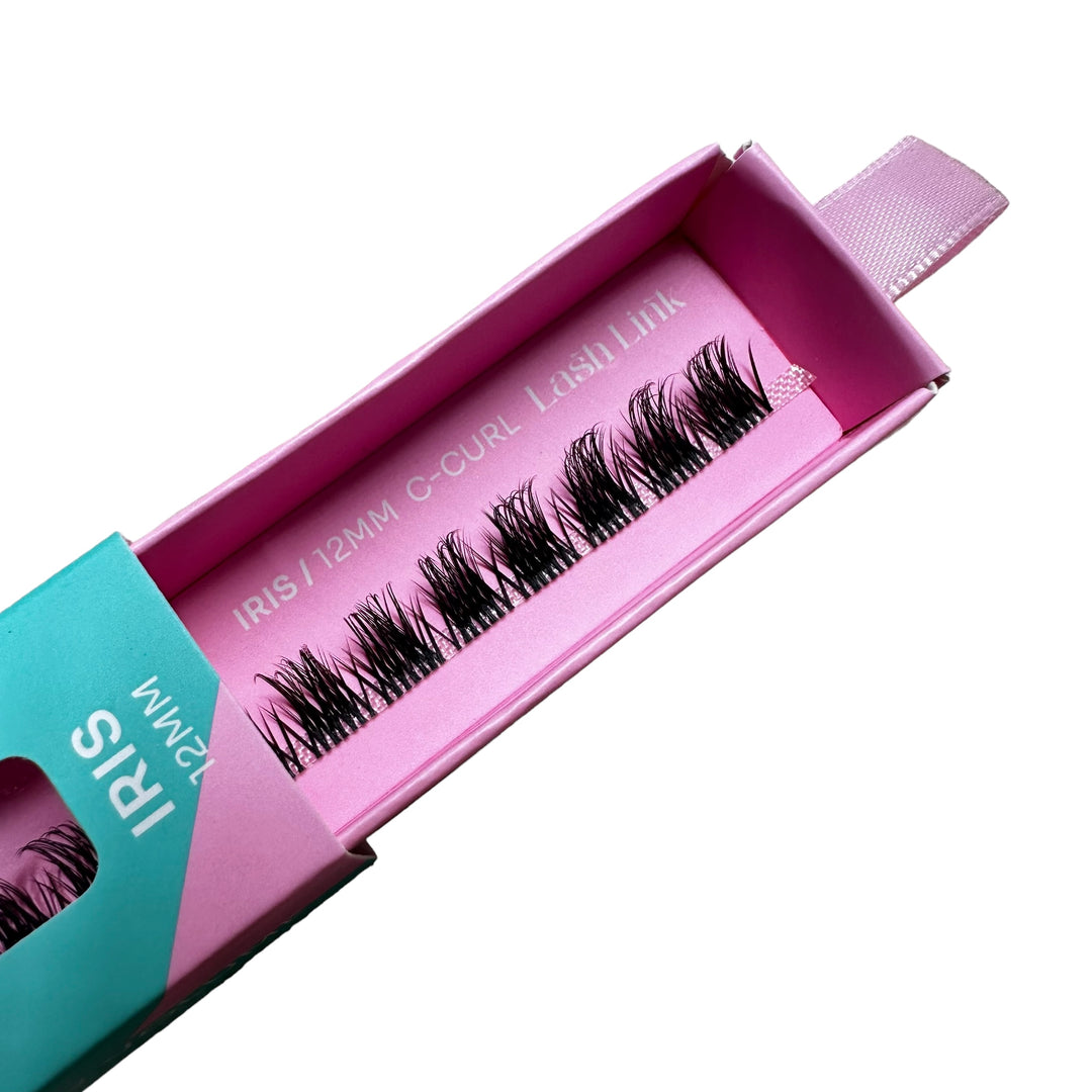 The pink box labeled "SPIKEY VOLUME | IRIS | LASH LINK LASH EXTENSIONS RIBBON" contains synthetic eyelashes from Lash Link, perfect for lash enthusiasts wanting to create dramatic, spikey volume with professional-grade extensions.