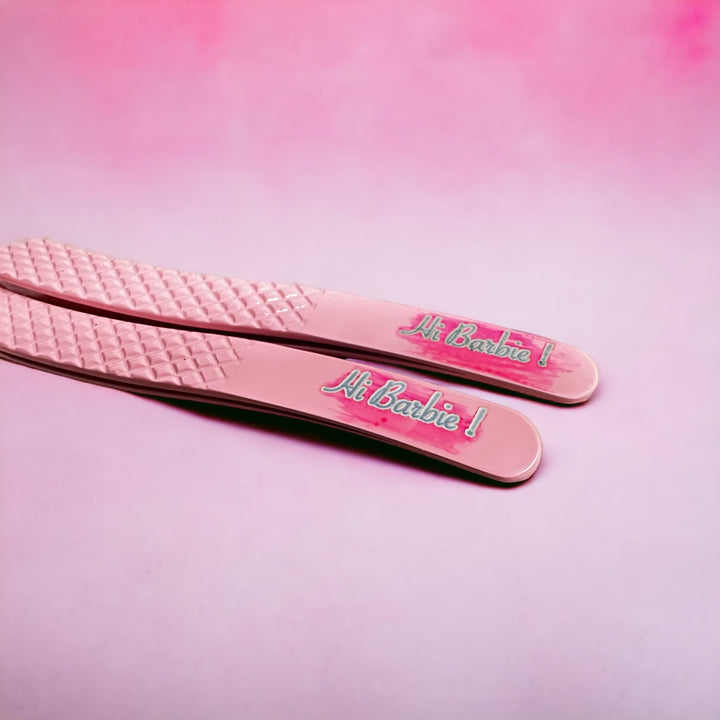 A pair of Limited Edition | Barbie Collection Nano Fibre Russian Volume Tweezers by Lash Tribe on a pink background.