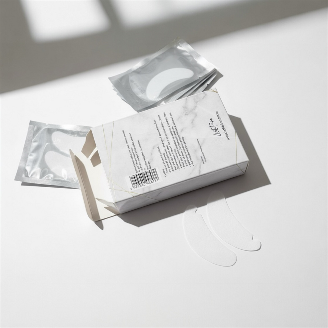 A box of Lash Tribe NEW Under Eye BIO Gel Pads, featuring two patches and individual foil packets on a white surface—ideal for eyelash extensions and safe for sensitive skin.