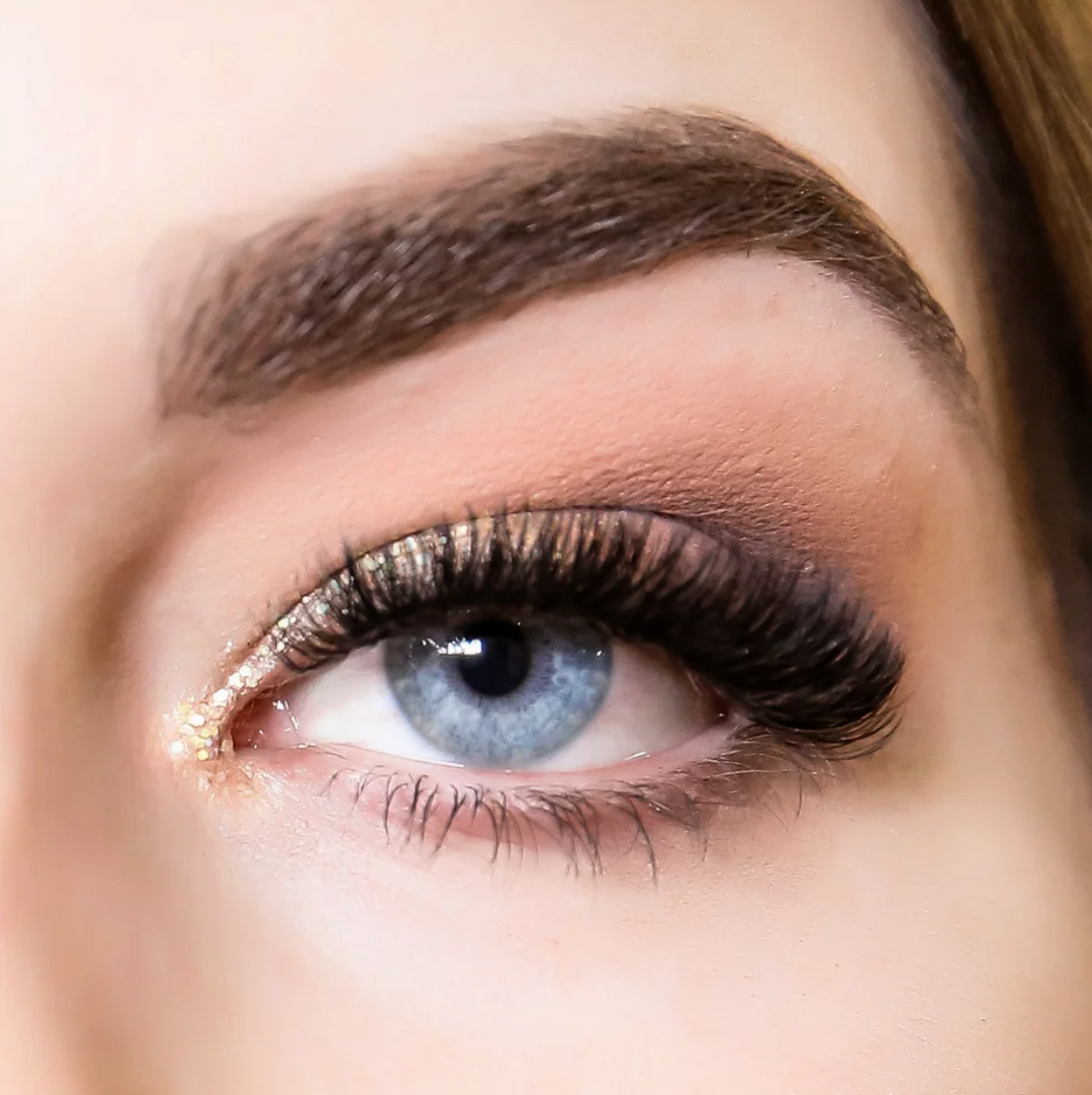Close-up of a person's eye with detailed makeup and long, luxurious Lash Tribe 0.03 Russian Volume Lashes -Mixed Tray | Premium Silk | Ultra Black.