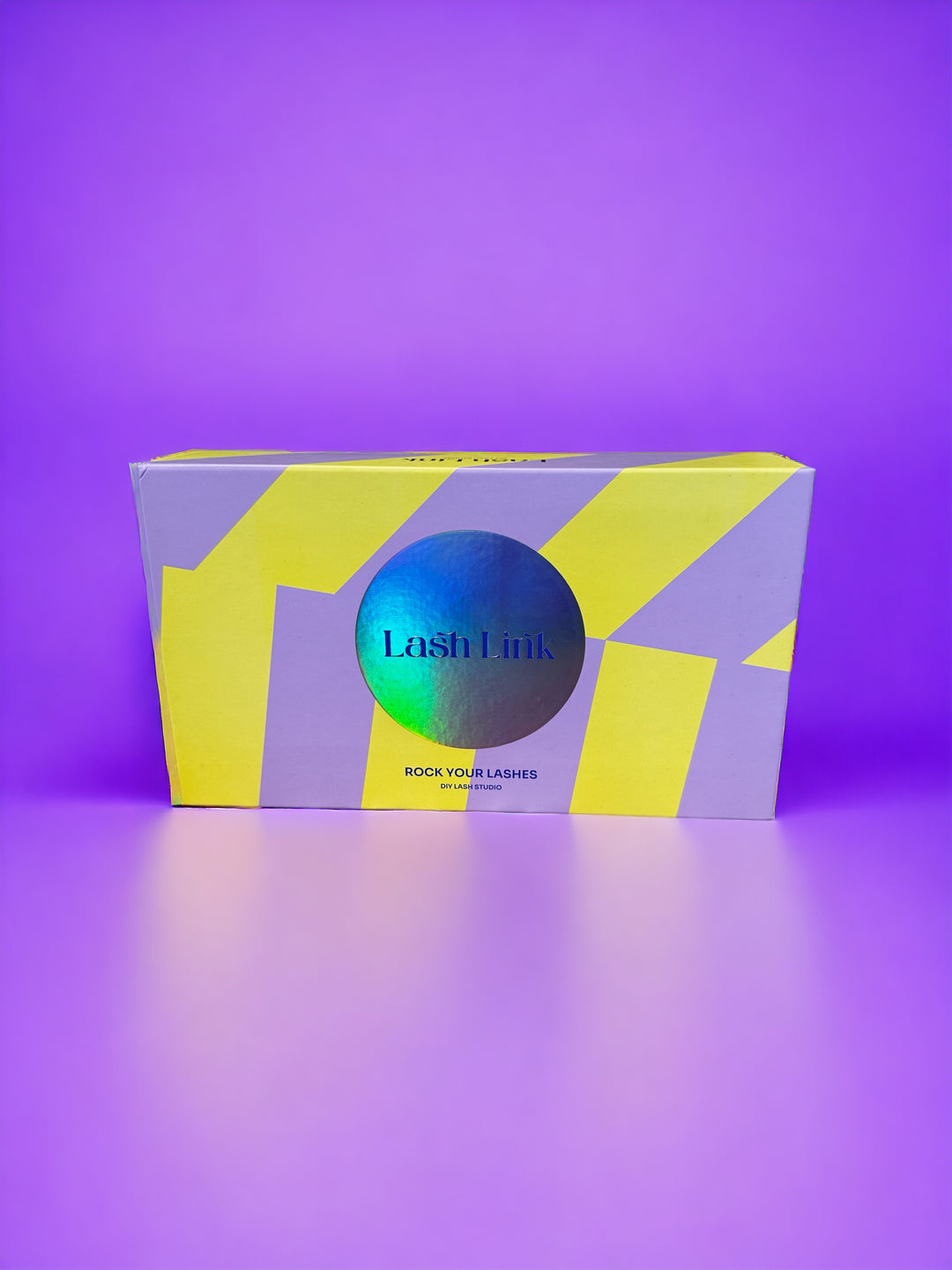 A yellow and purple Lash Link DIY Eyelash Extension Kit box on a gradient purple background, perfect for your Eyelash Extension Home Studio.