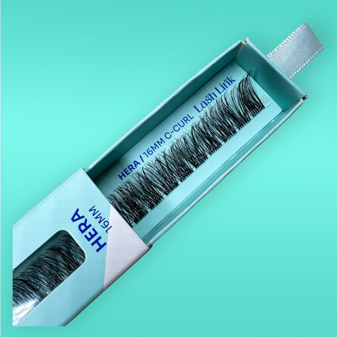 An open package of Lash Link's LIGHT VOLUME | HERA | LASH LINK LASH EXTENSIONS RIBBON in 16MM C-Curl false eyelashes on a light turquoise background, offering light volume lash extensions for a natural look.