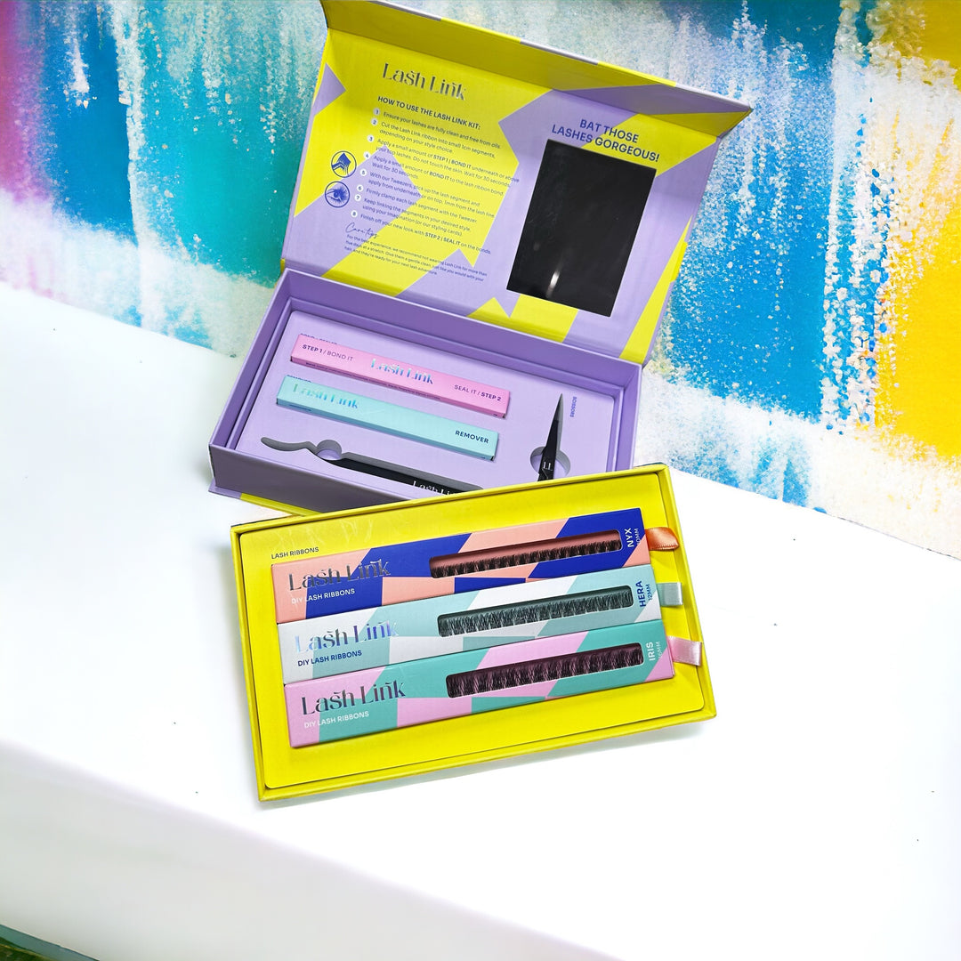 Open the box with the Lash Link DIY Eyelash Extension Kit and tools set on a white surface against a colorful background, perfect for creating your own Eyelash Extension Home Studio.
