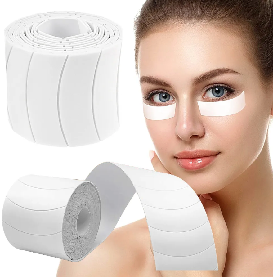 A woman's face with a roll of Lash Tribe 110 PCS Foam Eye Pads | Pre-Cut | Lint Free Under Eye Pads.