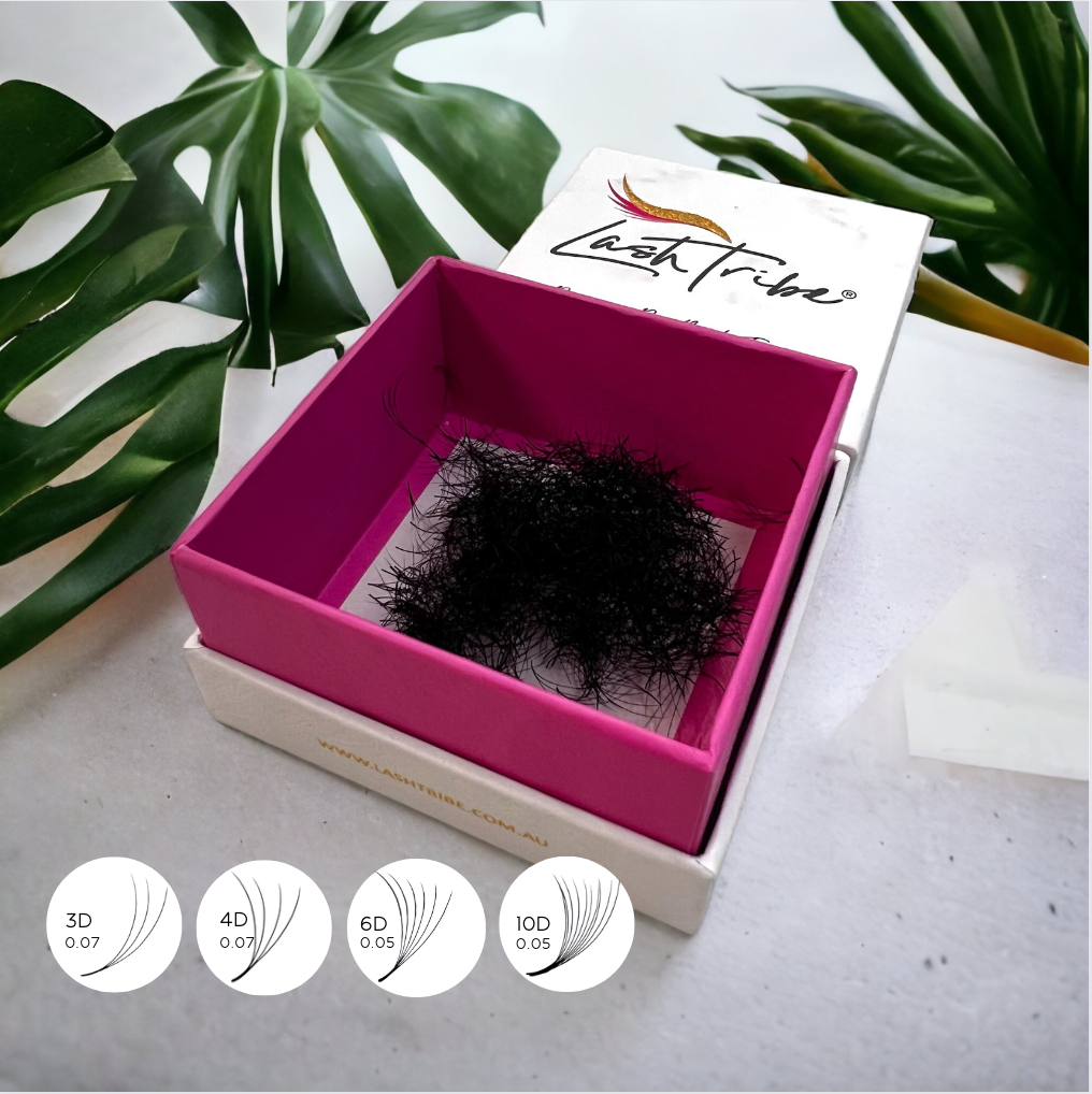 Loose Premade Volume Fans | Long Stem | Ultra Black in a pink box next to a plant by Lash Tribe.