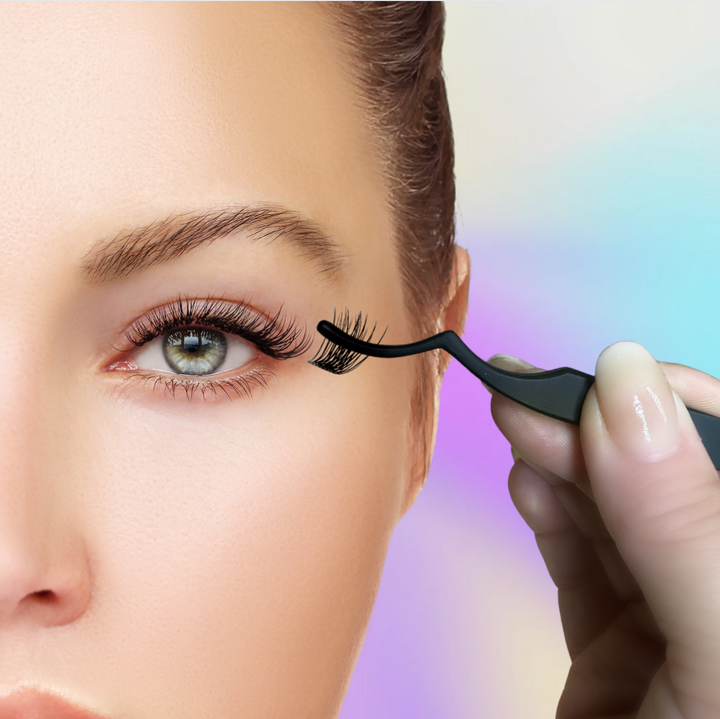 A skilled hand uses the Lash Link Applicator | Lash Segment Tweezer by Lash Link to apply false eyelashes to a woman's eye against a blurred, colorful background.
