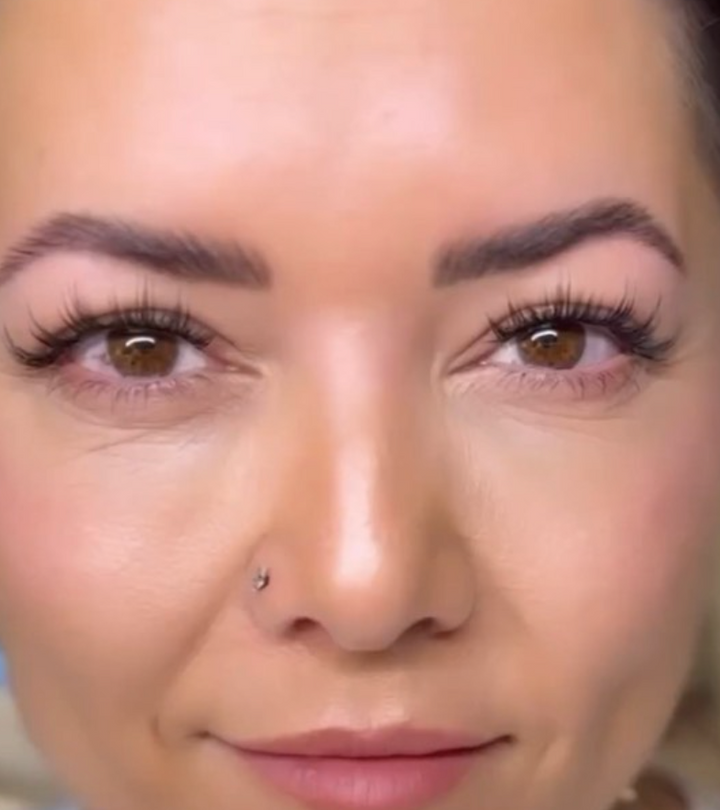Close-up of a person’s face showing long eyelashes, arched eyebrows, and a small nose piercing, perfectly complemented by Lash Link DIY Eyelash Extension Kit.