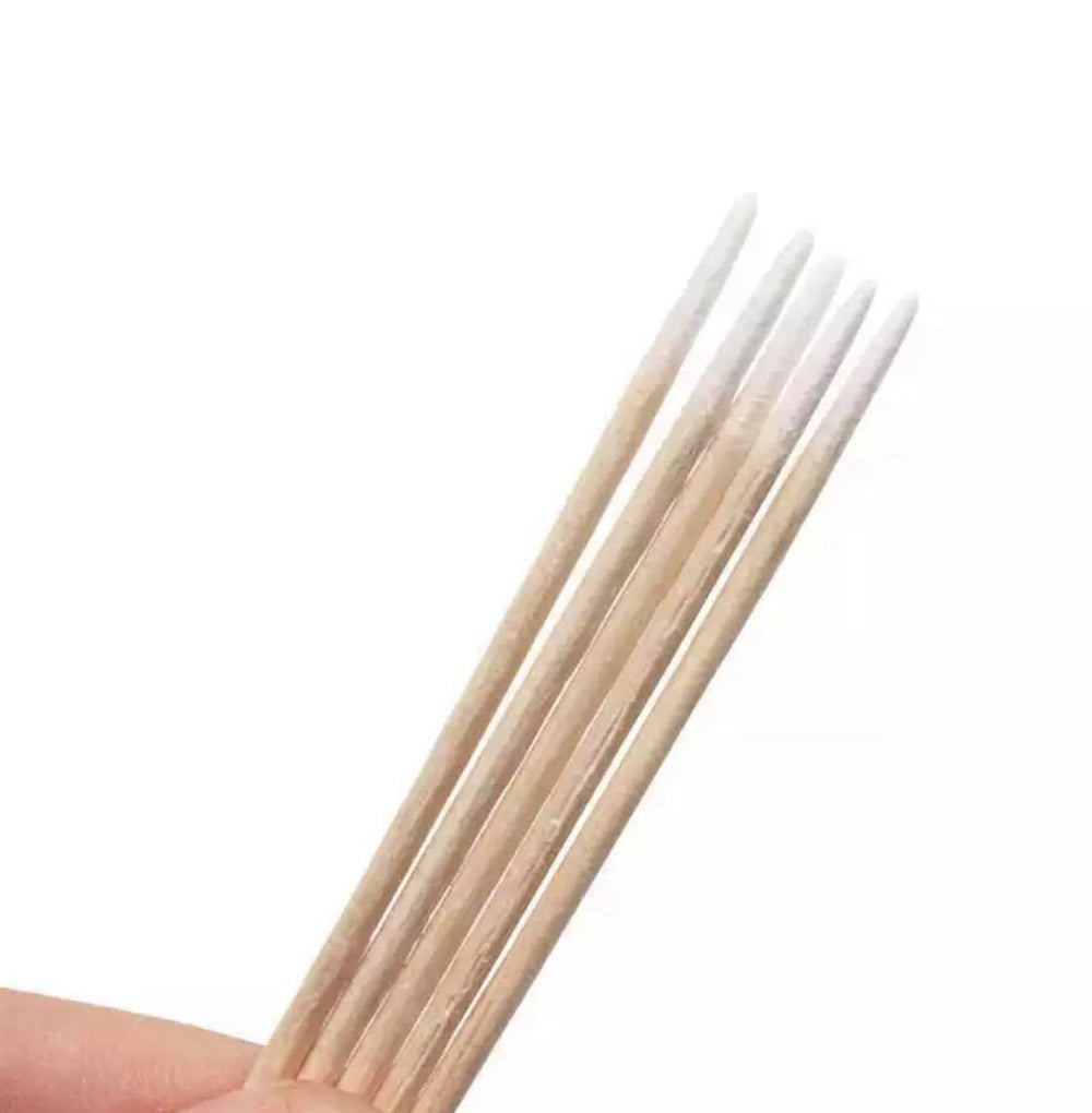 a person holding a set of white wooden cotton swab sticks from Lash Tribe.
