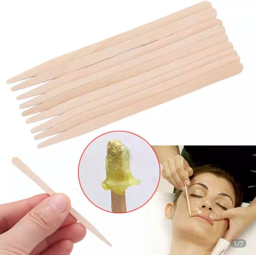 A person is using a Lash Tribe Disposable wooden waxing stick (Wax Spatulas) to make eyebrows.