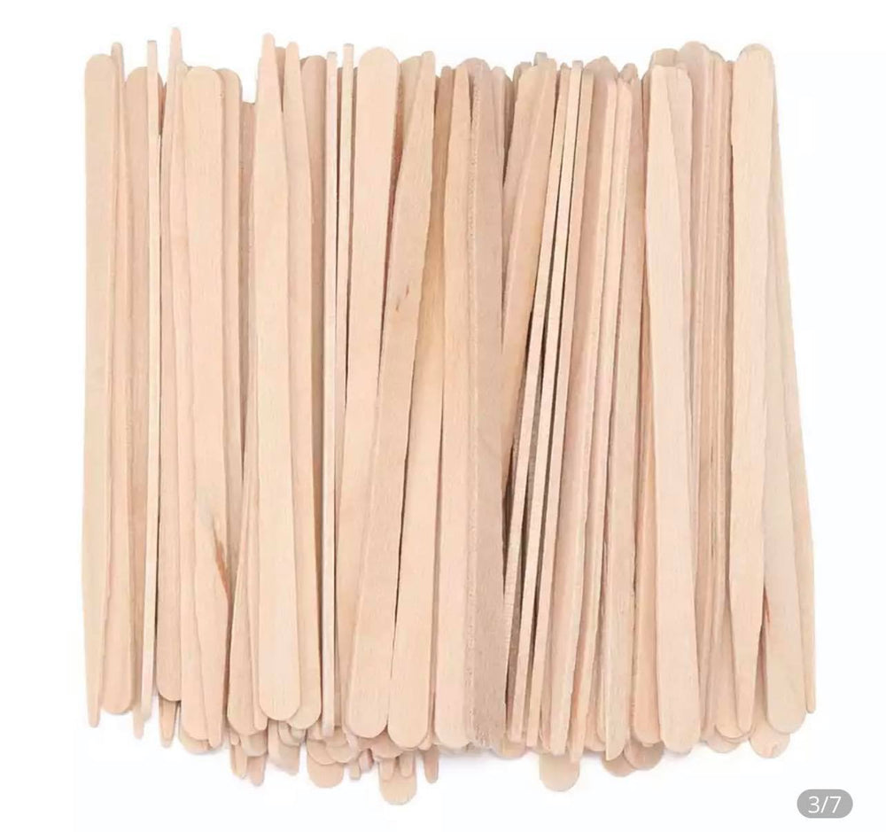 A pile of Disposable wooden waxing sticks on a white background.