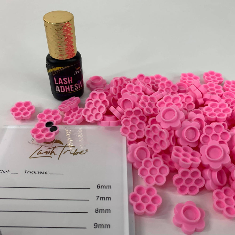 A Lash Tribe Lash Glue Holder Flower Cup and a bottle of beeswax.