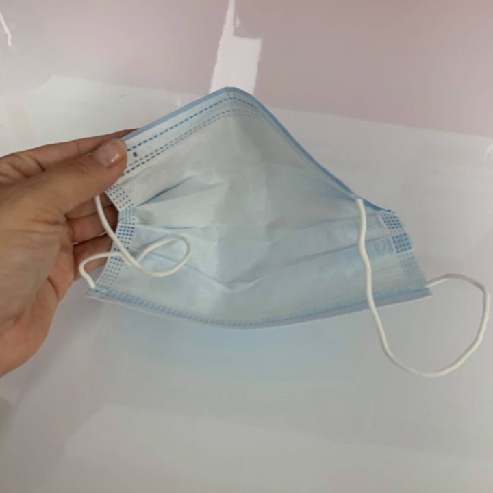 a person holding a Lash Tribe Surgical Face Mask.