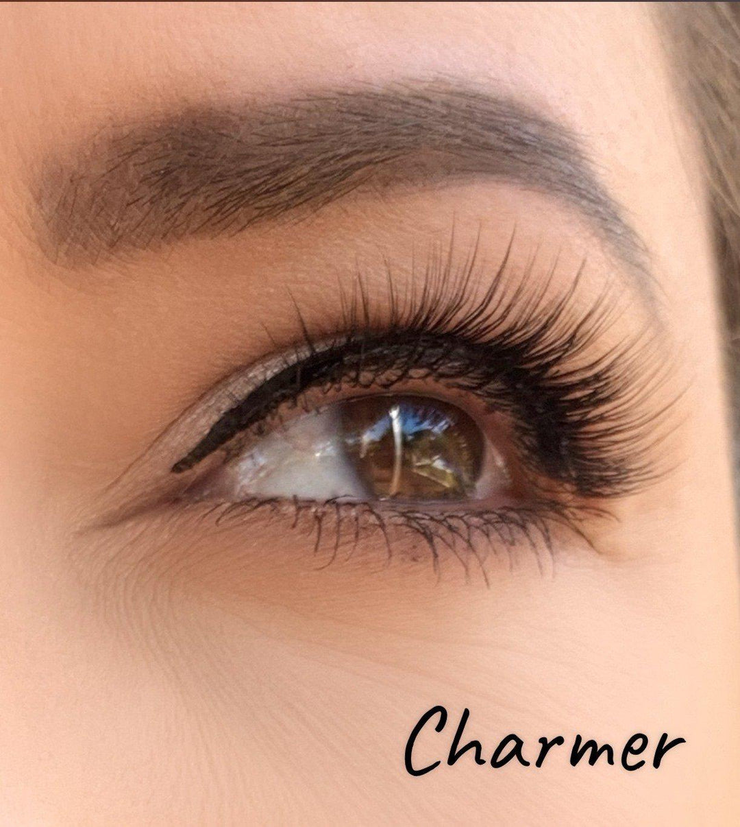 A woman's eye with Silk Magnetic Lashes & Liner Kit from Lash Tribe and the word charmer.