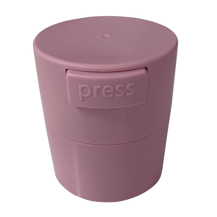 a pink plastic Lash Tribe container with the word press on it.