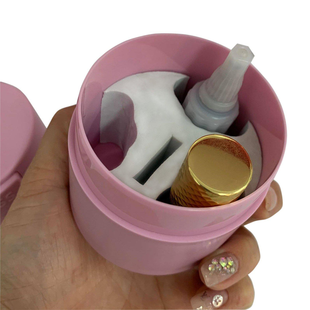 a person holding a Lash Tribe Lash Glue Storage Container with a gold lid