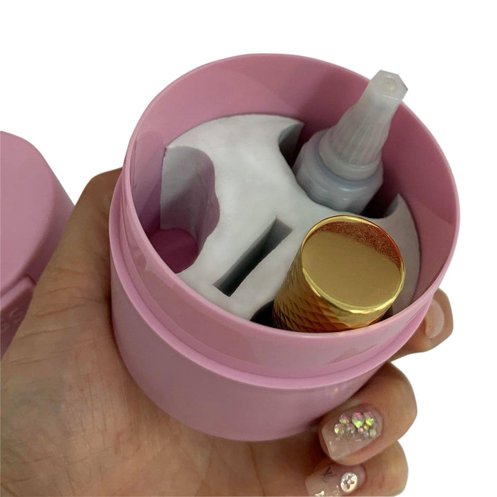 a person holding a Lash Tribe Lash Glue Storage Container with a gold lid