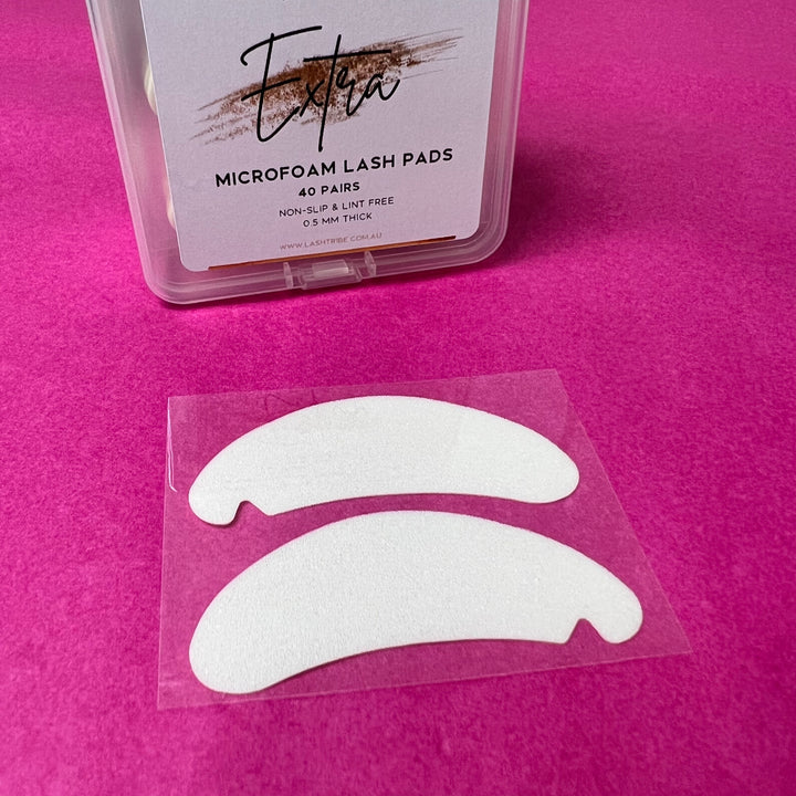 A pair of Microfoam Eye Pads on a pink background by Lash Tribe.