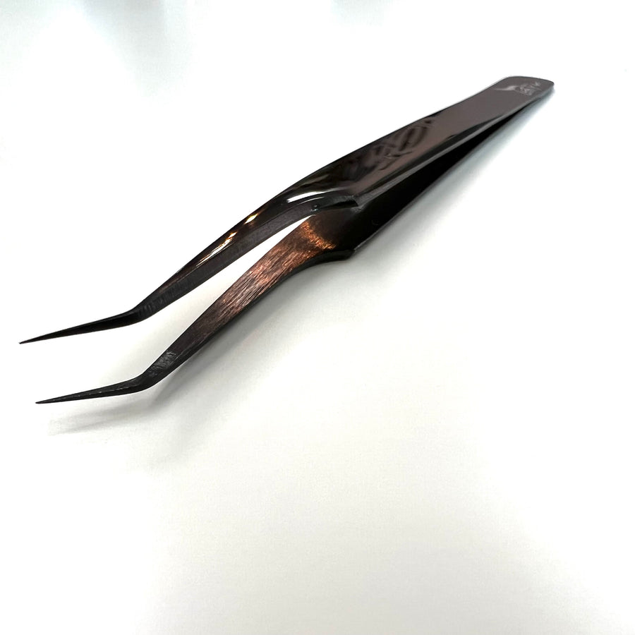 a pair of "The Swan" Angled Isolation Tweezers by Lash Tribe on a white surface.