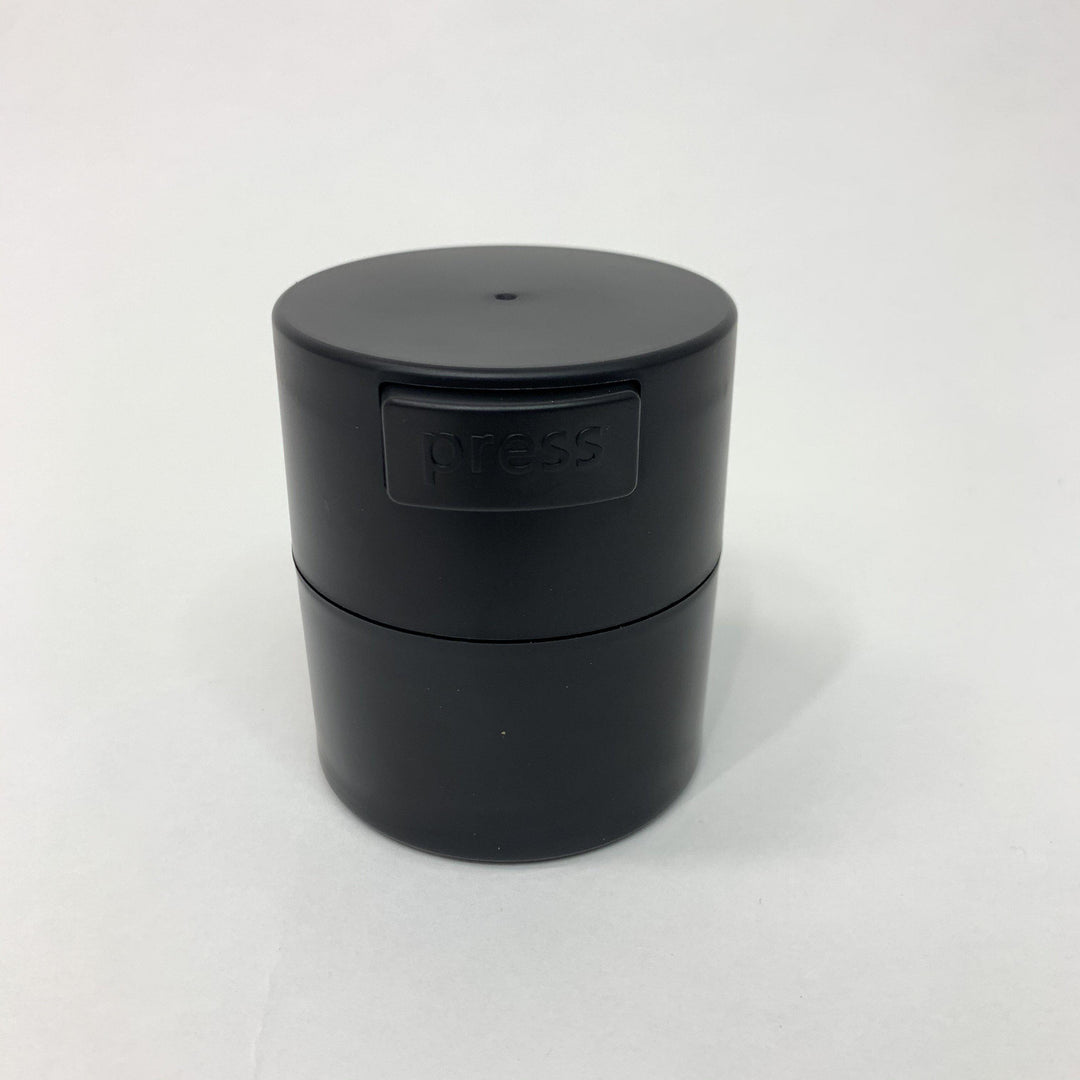 a Lash Tribe Lash Glue Storage Container with a lid sitting on a white surface.