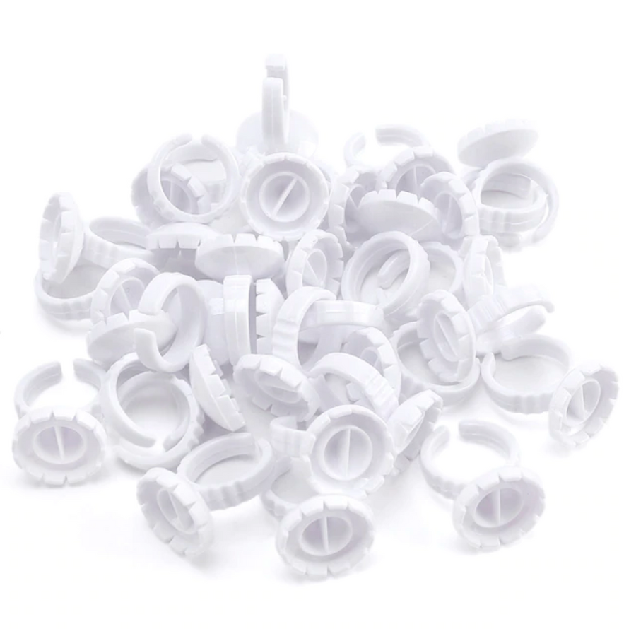 A pile of Lash Tribe Lash Glue Rings on a white background.