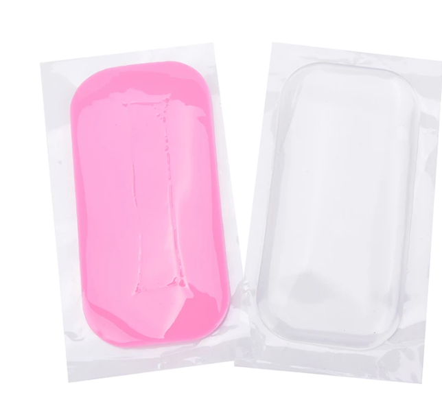 two Lash Tribe pink and white Silicone Lash Pads on a white surface.