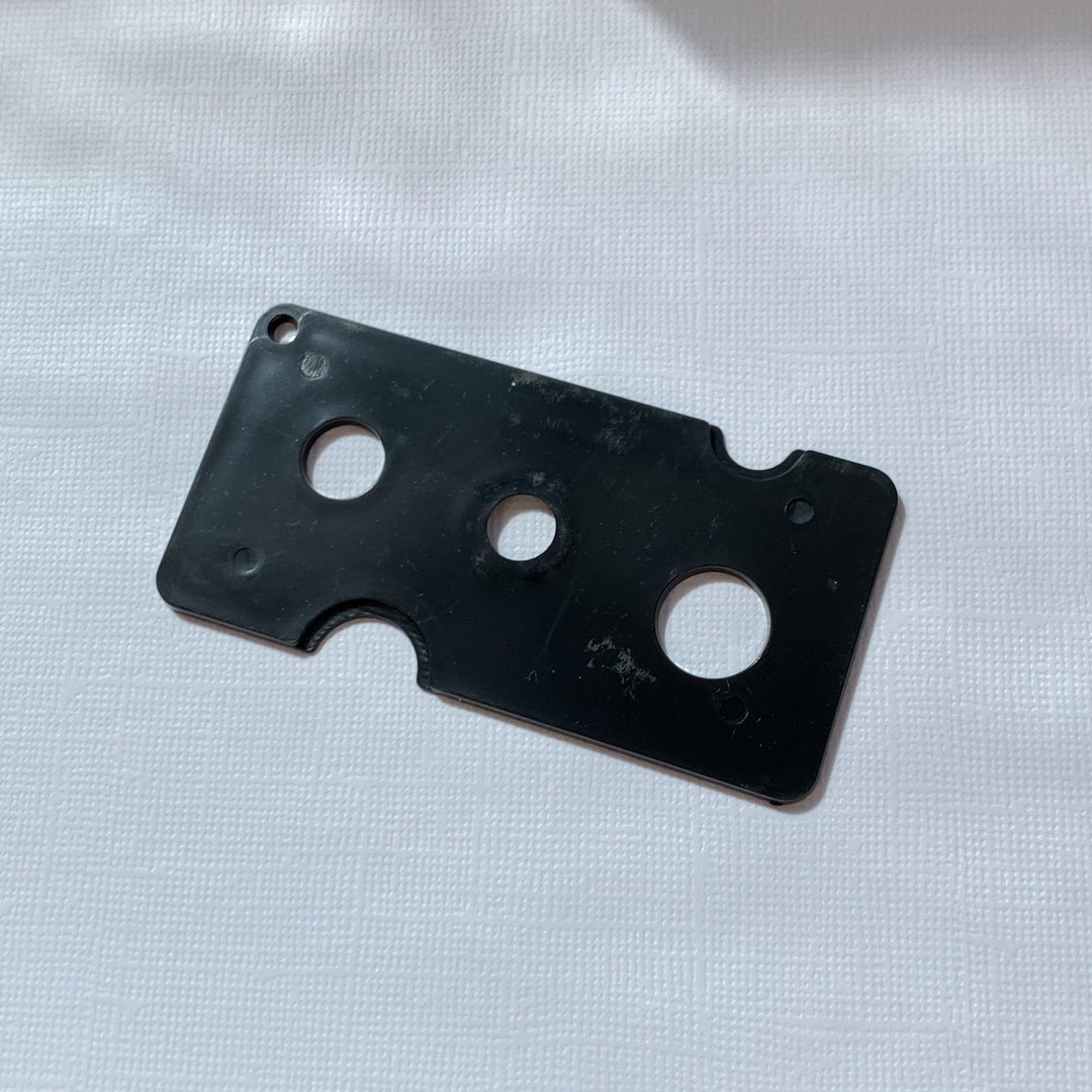 A black plastic plate with holes on it, designed for Lash Tribe adhesive nozzle opener to effectively remove stuck nozzles on Lash Glue.
