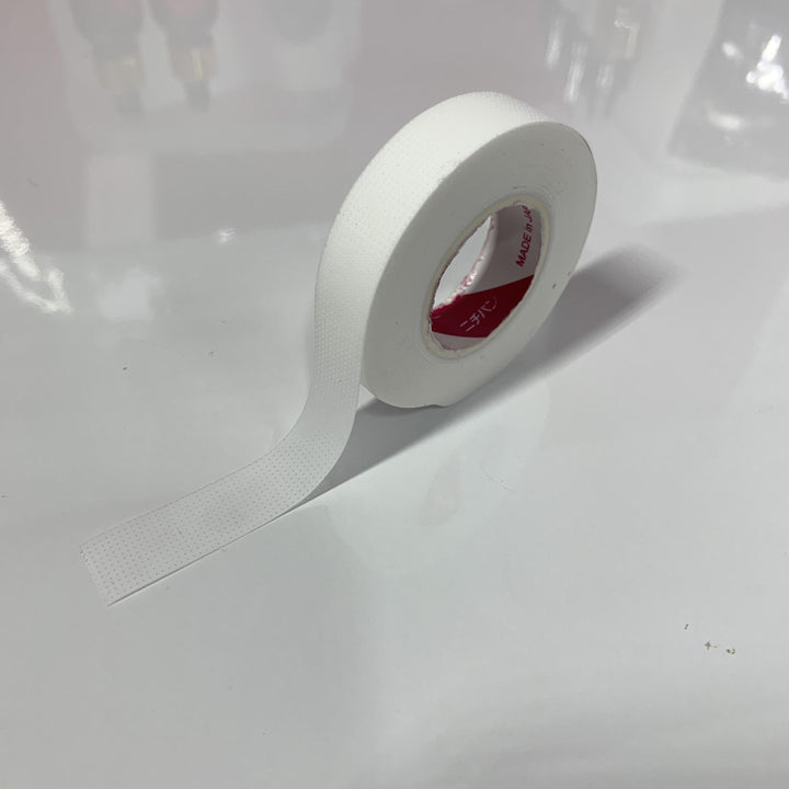 A roll of Japanese Comfort Lash Tape by Lash Tribe sitting on a table.