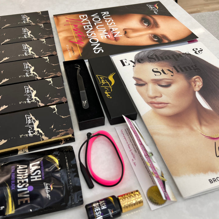 An array of Lash Tribe eyelash extension products, including adhesives, tools, and the "Russian Volume Manual" featuring models on a table.