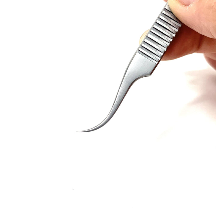 a person holding a small Volume Master | Curved Precision Tweezer by Lash Tribe on a white surface.