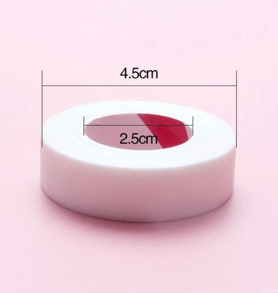 A roll of Japanese Comfort Lash Tape with measurements on a pink background, by Lash Tribe.