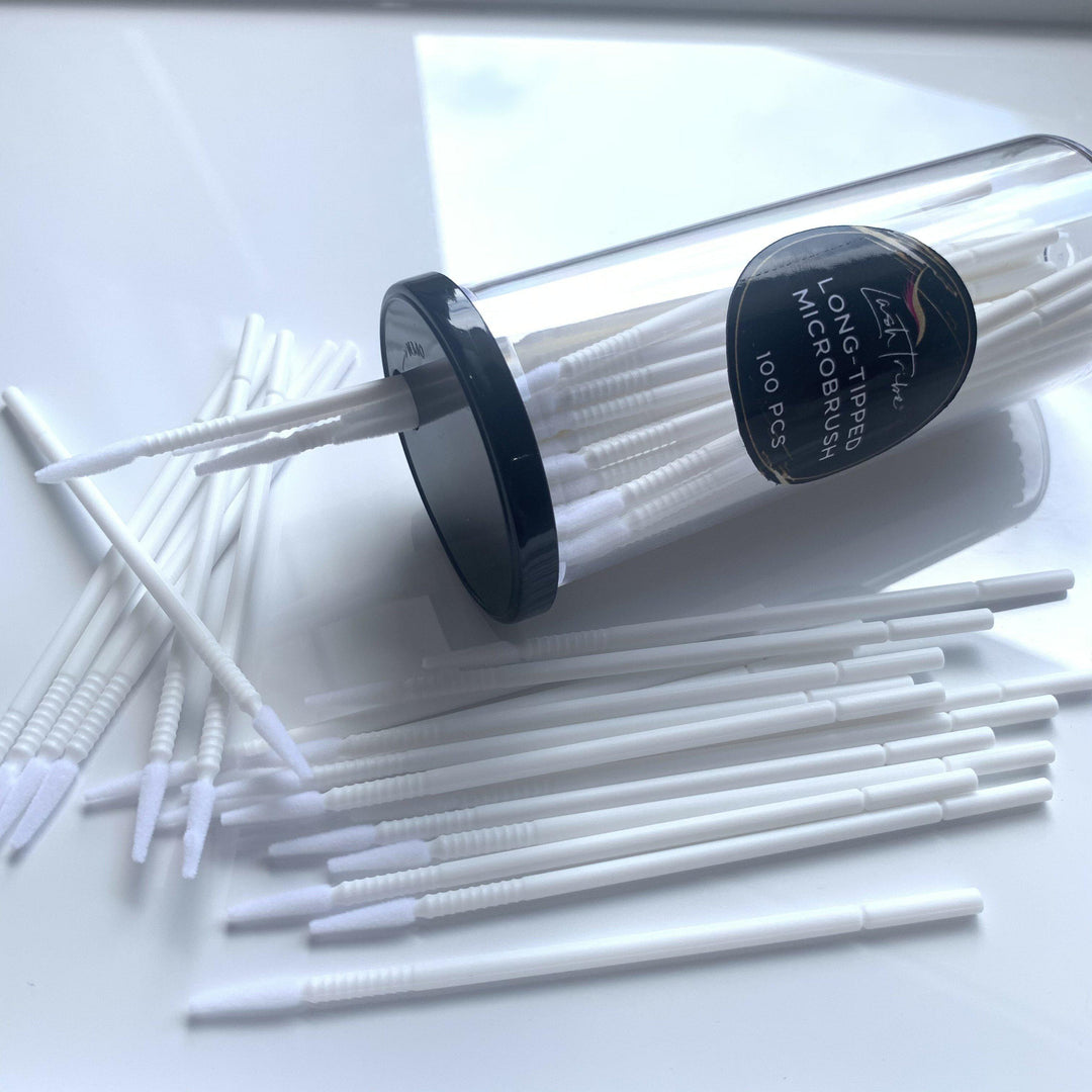 Long-tipped Micro brushes by Lash Tribe in a container on a table.