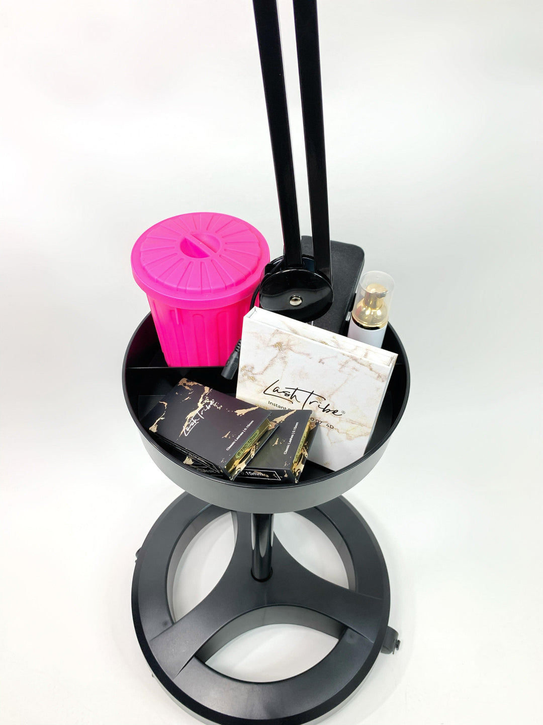 A Lash Tribe black tray with a Lash Light with Storage Tray | Lash Salon Light pink bottle and other items on it.