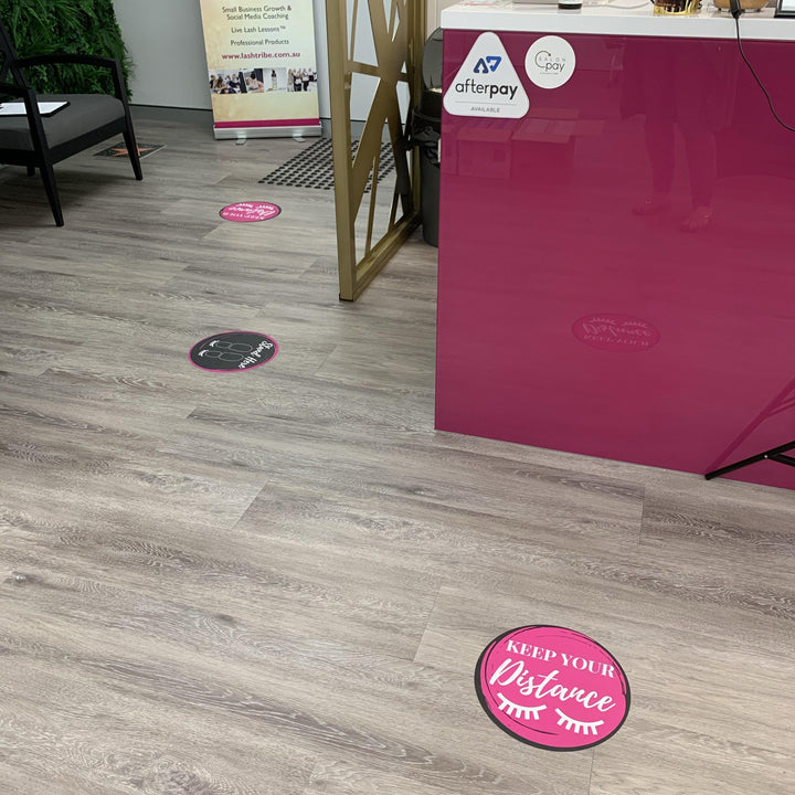 a pink and white office with a Social Distancing Floor Sticker by Lash Tribe on the floor.