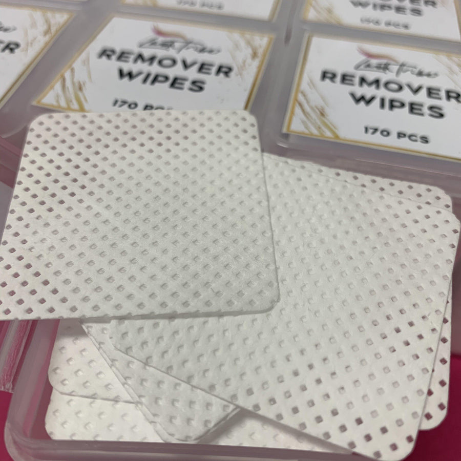Lash Tribe Lash Glue Remover Wipes in plastic containers on a pink background.
